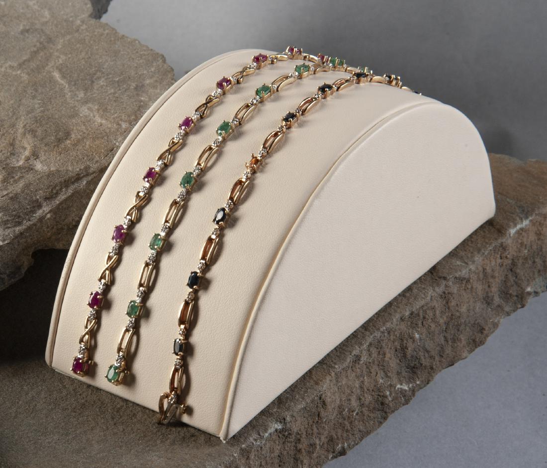 3 10K Gemstone & Diamond Bracelets: DESCRIPTION: Three 10k gemstone and diamond link bracelets: ruby, emerald & sapphire. MEASUREMENTS: 11.2 dwt (17.4 gr). Each 7-1/4" to 7-1/2" long. CONDITION: Very light wear. Sapphire bracelet missin