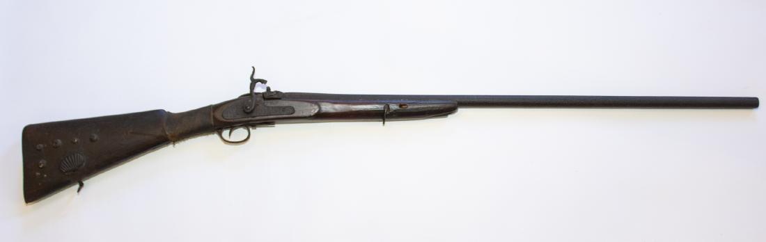 Antique Rifle: DESCRIPTION: Antique rifle. Brass tacking to stock. Shell patch box. Leather wrap at wrist. 19th century relic. MEASUREMENTS: 45-1/2" long x 1-1/2" wide.
