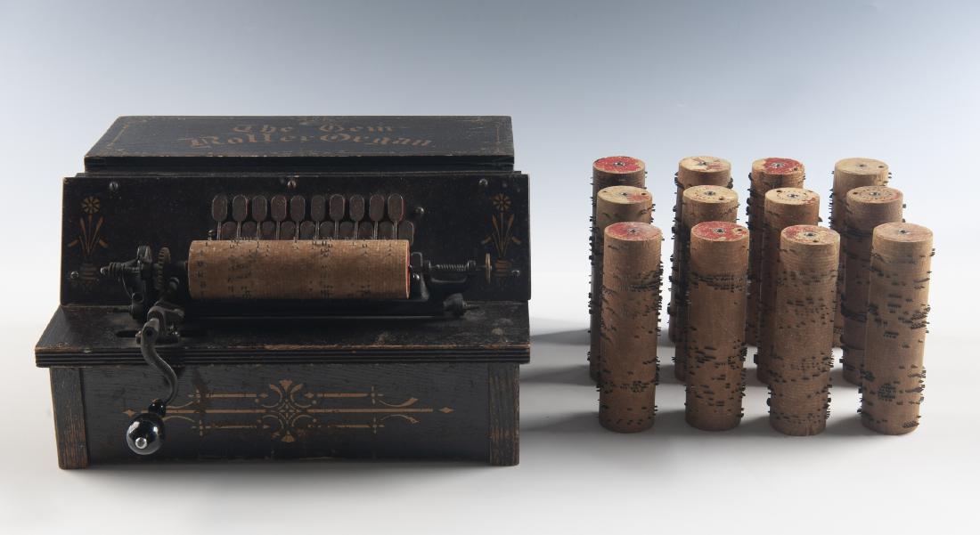 Gem Roller Organ Music Box with 12 Cylinders: DESCRIPTION: Gem Roller Organ music box. Circa 1880s. Wood case painted black with a stenciled motif and "THE GEM ROLLER ORGAN" in gold, metal keys and teeth, open roller frame, metal hand crank with