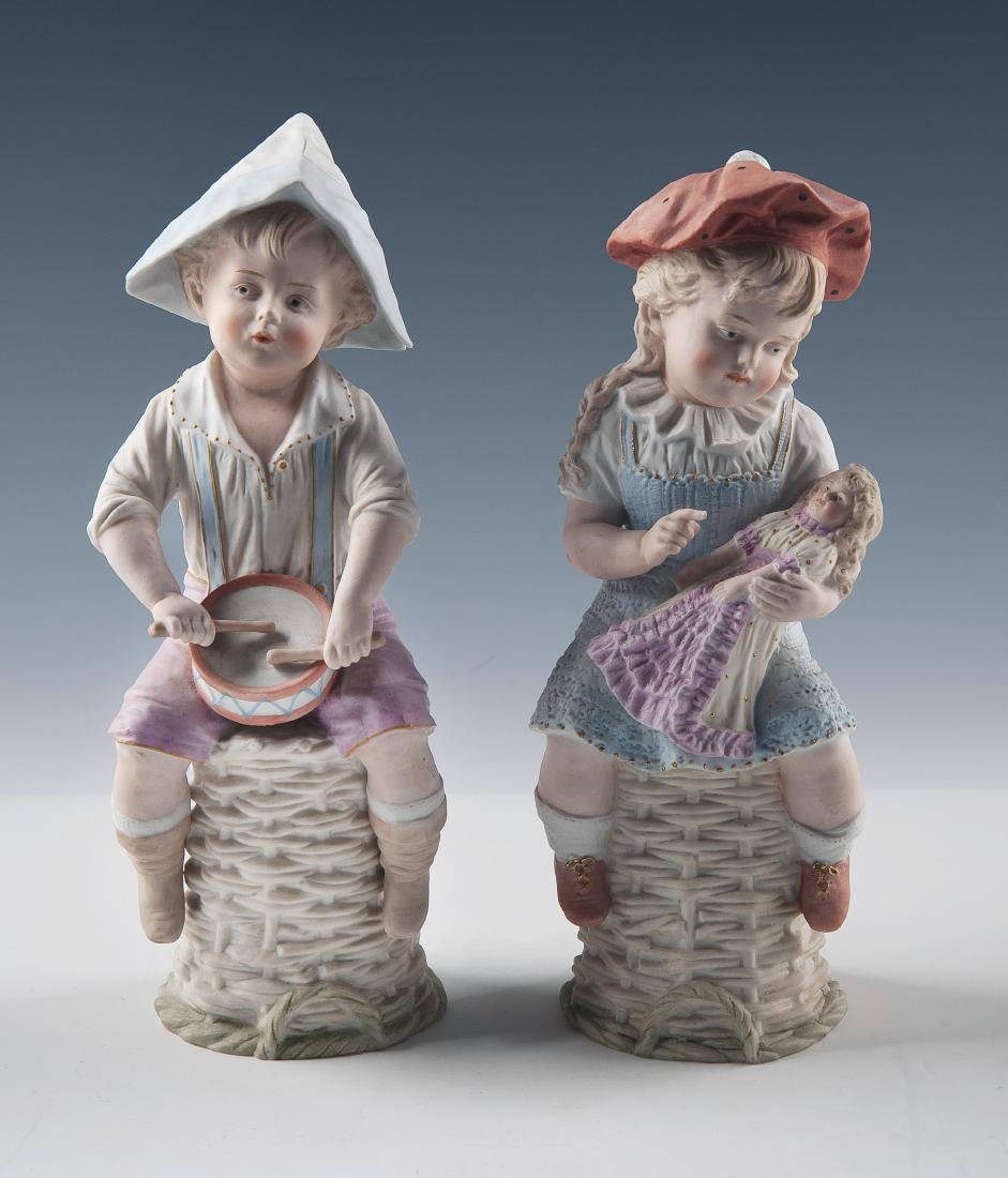 Pair of Heubach Bisque Figures Boy and Girl: DESCRIPTION: Pair of Heubach bisque porcelain figures. A girl with a doll and a boy with a drum. Each with Heubach sunset mark circa 1882-1905. MEASUREMENTS: Each 12-1/2" high x 4" wide. CONDITION: No