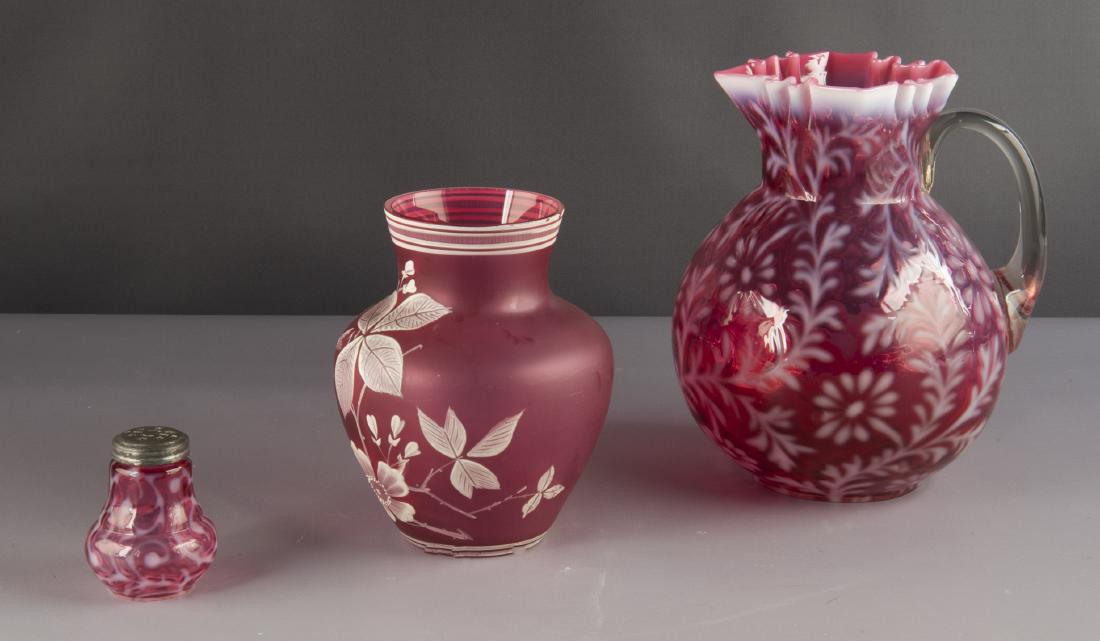 3 Pcs Victorian Cranberry Art Glass: DESCRIPTION: Three pieces Victorian cranberry art glass. Includes 8-3/4" Spanish lace water pitcher with applied scroll handle and square crinkle rim, 2-3/4" Spanish lace shaker, and 6-1/2" frosted cr
