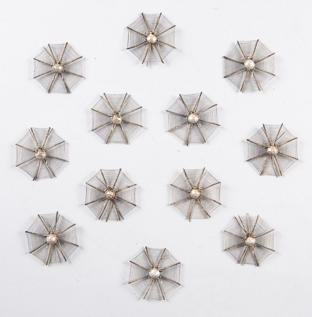 11 Chinese White Metal Spider Place Card Holders: DESCRIPTION: Eleven Chinese white metal place card holders in form of spiders in webs. Wirework octagonal spider webs. With spider in center and easel legs. MEASUREMENTS: Each 2-1/2". CONDITION: Good.