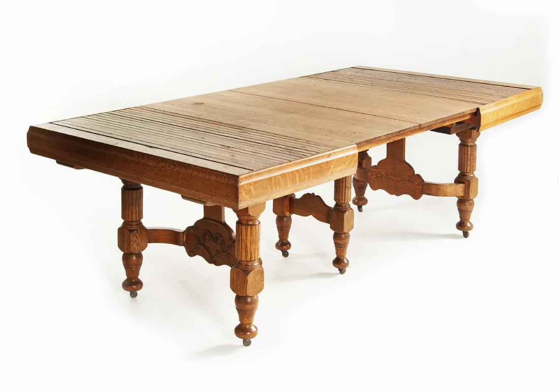 Golden Oak Dining Room Table: DESCRIPTION: Late 19th or early 20th century golden oak dining room extension table in an Eastlake style. Six turned legs supporting a rectangular fold out table top. Unusual tambour extensions. MEASU