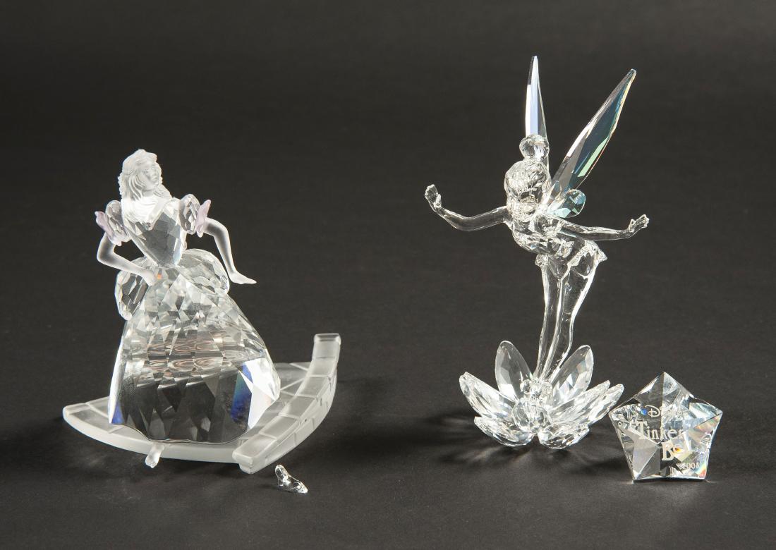 2 Swarovski Disney Figurines: DESCRIPTION: Two Swarovski Disney figurines. Includes 2008 Tinker Bell and Cinderella. Tinker Bell with star shaped plaque. Cinderella with shoe. Each in ob. CONDITION: Excellent. Boxes with light she