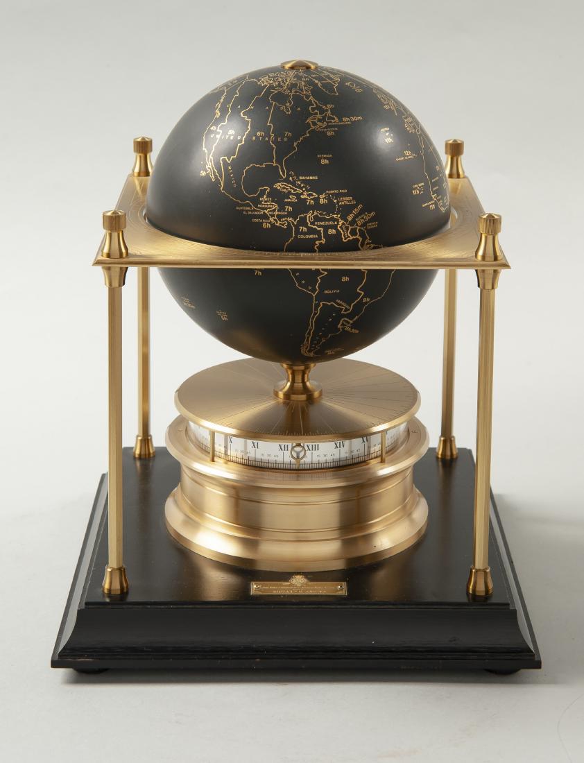 Royal Geographic Society World Clock: DESCRIPTION: World Geographic Society world clock. Brass base with 24 hour Roman numeral chapter circlet below satin finish globe with 24 karat gold lines outlining continents and time zones. Eight da