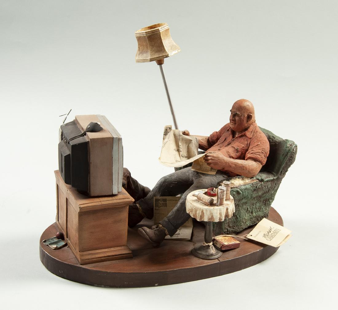 Michael Garman (America, 1938-Present): DESCRIPTION: "Evening News" by Michael Garman (American, 1938-Present). 1984 Hand painted sculpture depicting man sitting on couch watching tv and reading the newspaper. His dog is at his feet with be