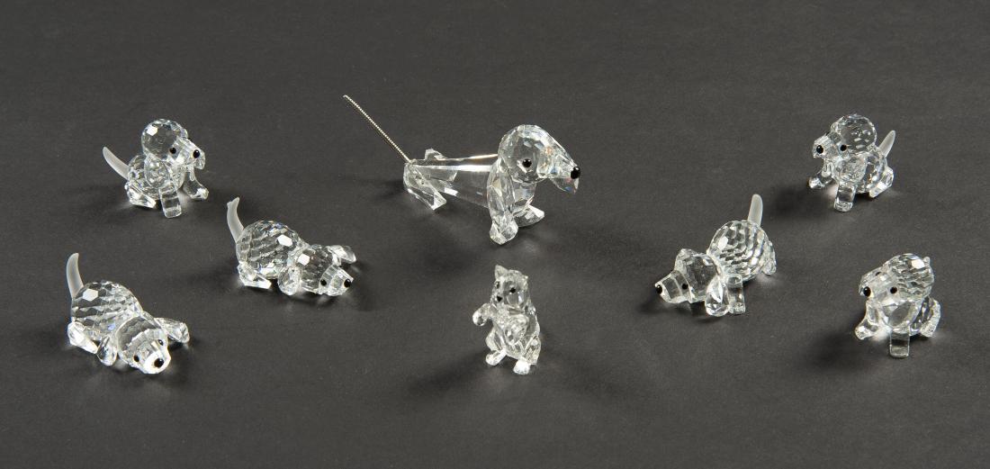 8 Swarovski Pets: DESCRIPTION: Eight Swarovski pets. Includes three playing beagles, three beagles, one daschund, and one cat. Each in ob. MEASURMENTS: Ranges from 1" high to 1-1/2" high. CONDITON: Shelf wear to boxes.