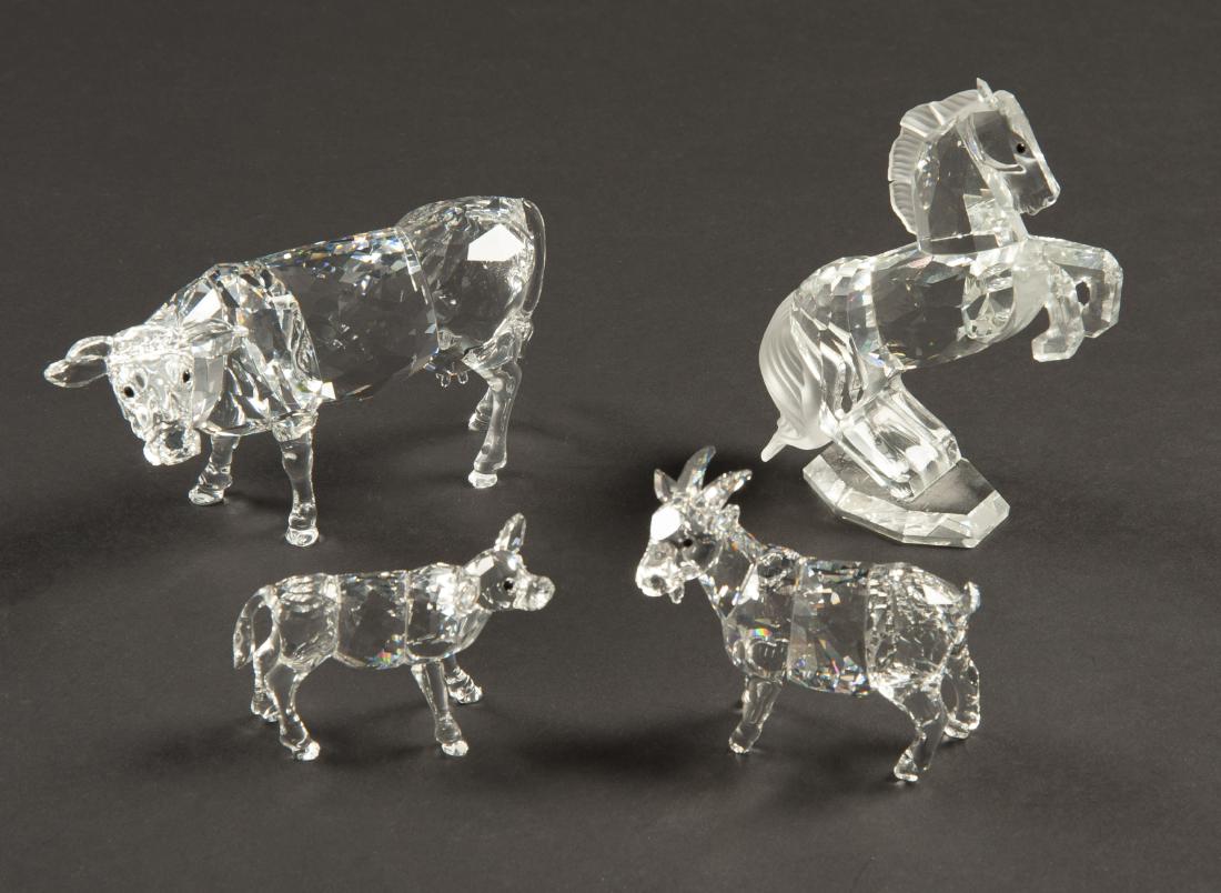 4 Swarovski Farm Animals: DESCRIPTION: Four Swarovski farm animals. Includes cow, calf, goat, and horse. Each in ob. MEASUREMENTS: Ranges from 1-3/4" tall to 4" tall. CONDITION: Horse missing one ear. Boxes with shelf wear.