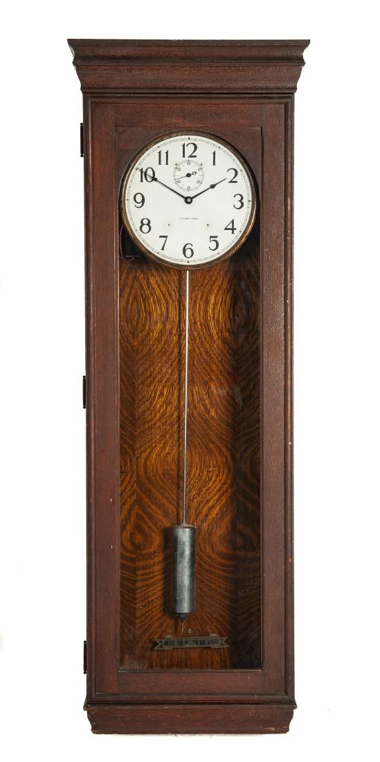 International Time Recording Co. Master Clock: DESCRIPTION: International Time Recording Company master clock. Painted metal dial with Arabic numerals and subsidiary second hand. With single pendulum. Oak case with single door. MEASUREMENTS: 22" w