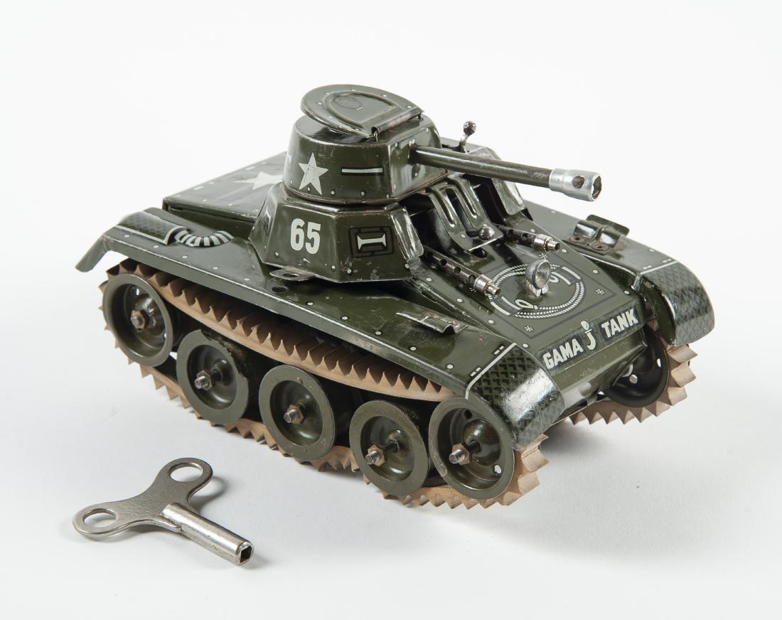 Gama 65 Montage Tank Windup Tin Toy: DESCRIPTION: Gama 65 Montage tank windup tin toy. Made in U.S. Zone Germany. Features detailed litho and rubber tracks. Circa 1940s. Includes key. MEASUREMENTS: 3-3/4" x 6-3/4" x 4". CONDITION: Missin