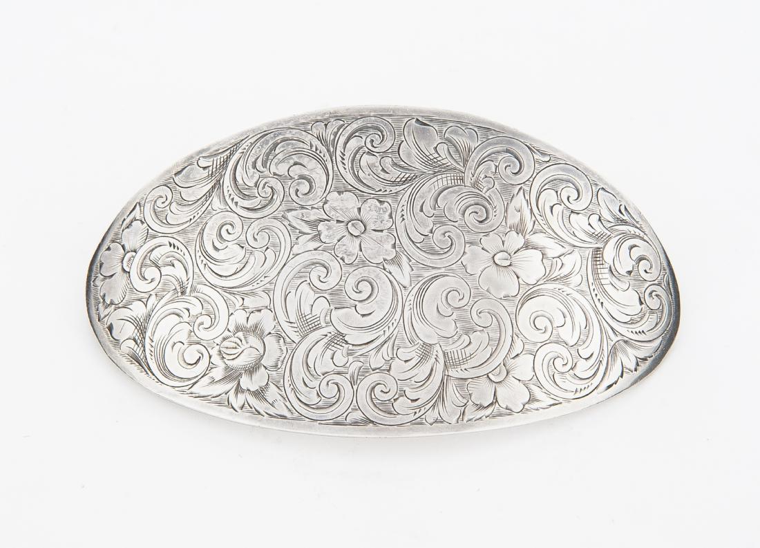 William Kerr Sterling Brooch: DESCRIPTION: William Kerr oval sterling brooch with floral design. Marked "Sterling 3122 A" with pictorial axe. MEASUREMENTS: 3-1/4" long x 2-7/8" wide. 1.1 troy ounces. CONDITION: Good.