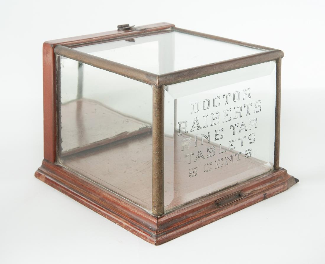Schmitt & Co Countertop Display Case: DESCRIPTION: Schmitt & Co. etched glass, wood, and nickel countertop display case. Front advertisement reads "Doctor Raiberts Pine Tar Tablets 5 Cents" and includes original metal tag that reads "Schm