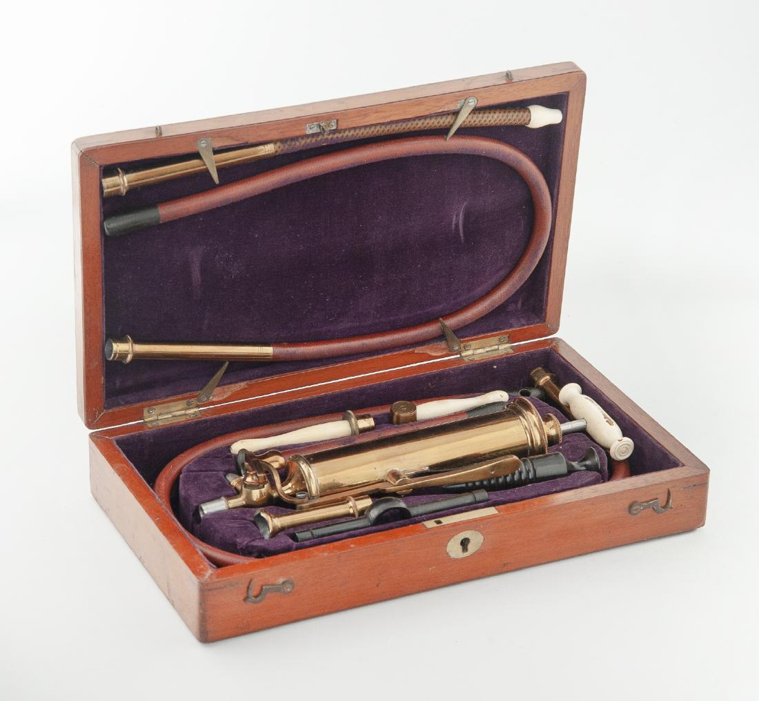 Antique Doctor's Enema Set in Case: DESCRIPTION: Antique doctor's enema medical pump and accessories in wood case. With bone handles and fittings. Case with hinged lid, gilt wood inlay, and purple velvet lining interior. Faint monogram 