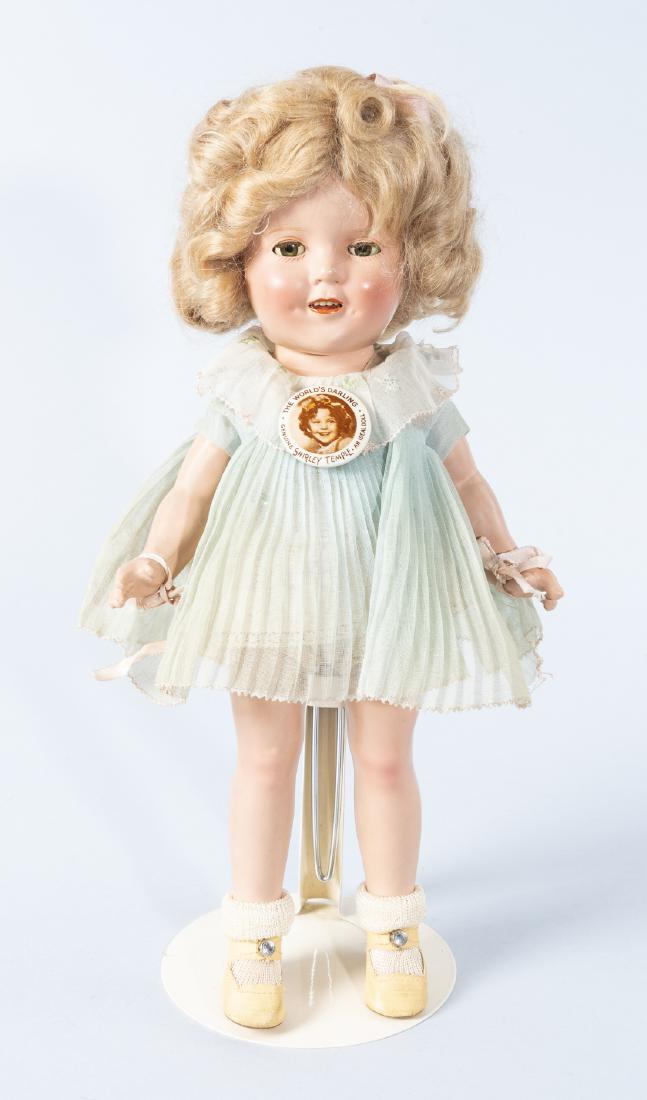Ideal 13" Shirley Temple Doll in OB: DESCRIPTION: Ideal Novelty and Toy Company 13" composition Shirley Temple doll in original box. Wearing original blue dress, rayon socks, and leatherette shoes. With Shirley Temple button pin, sleep e