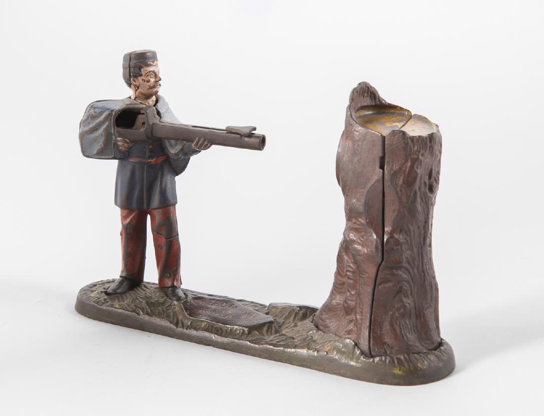 J.E. Stevens Creedmoore Mechanical Bank: DESCRIPTION: J.E. Stevens Creedmoore cast iron Mechanical Bank. Cast iron with polychrome paint decoration depicting a soldier firing into a tree trunk. Impressed “Creedmoor Bank, Pat. Nov. 7, 1877�