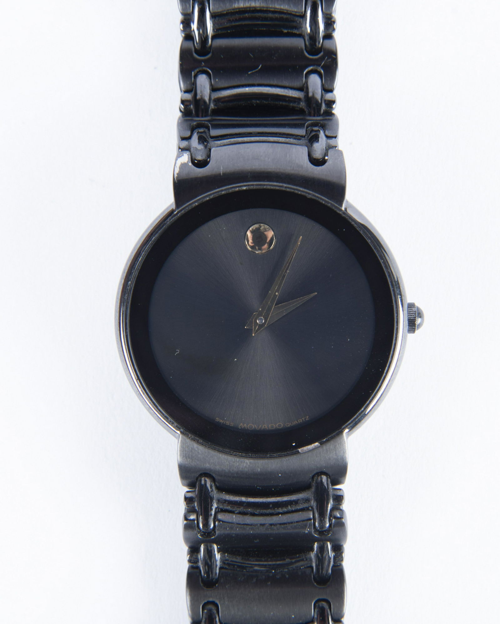 Movado Wrist Watch: DESCRIPTION: Movado wrist watch with black metal case and stainless steel back. SN# 8287165. MEASUREMENTS: 1-1/2" lug to lug. CONDITION: Light wear. Working. Requires 364/363 battery (not included).