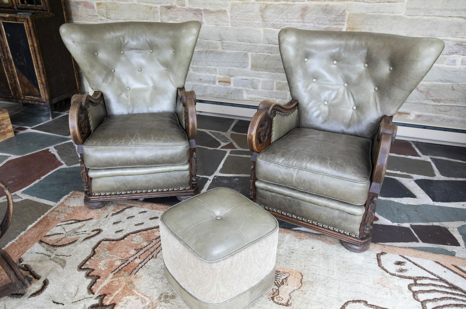 2 Leather Rectory Chairs with Ottoman: DESCRIPTION: Pair of rectory chairs with tufted green leather backs, carved arms and corners, and nail head detail. With matching square ottoman. MEASUREMENTS: Chairs: 35" wide x 39" deep x 39" high.