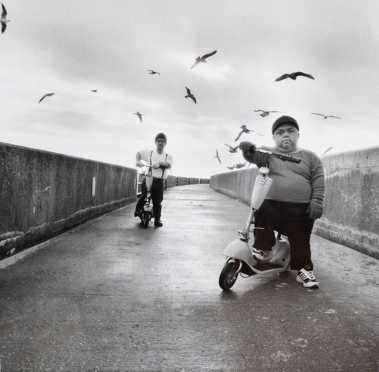 Michal Chelbin (Israeli, b. 1974): DESCRIPTION: Michal Chelbin (Israeli, b. 1974). Gelatin silver print. The Scooters. 2003. From "Strangely Familiar". Matted in black frame. MEASUREMENTS: Sight 16-1/2" x 16-1/2". Overall with frame 25