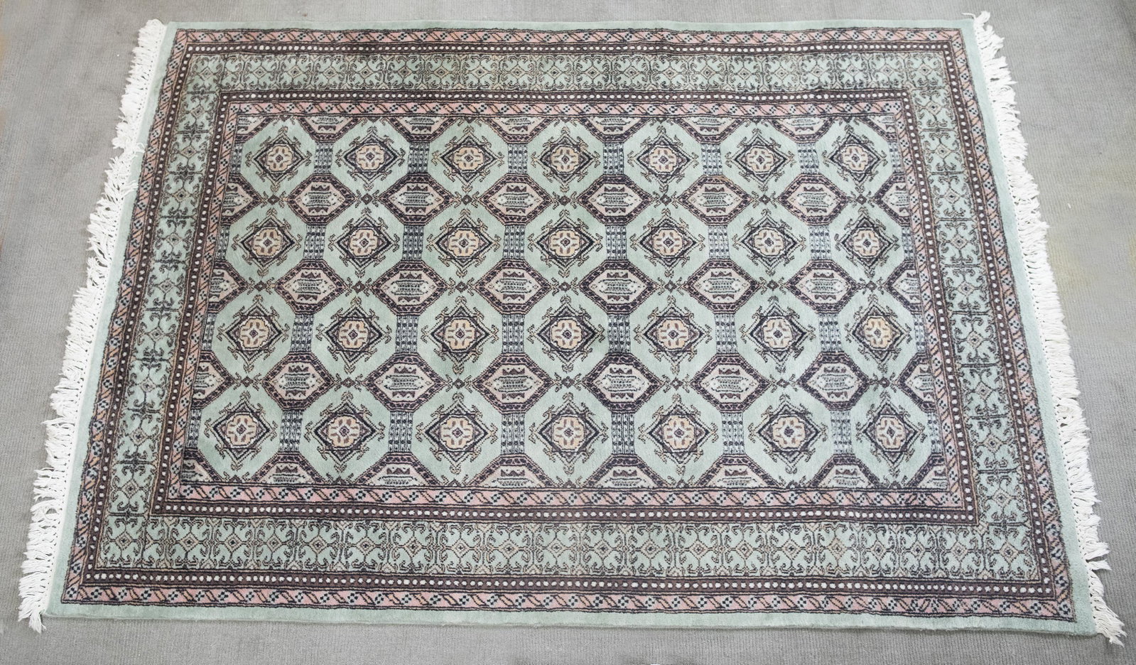 Pakistan Bokhara Area Rug: DESCRIPTION: Pakistan Bokhara area rug. 1980's. Pink and brown pattern on light blue field. MEASUREMENTS: 7'5" x 5'1". CONDITION: Very good.