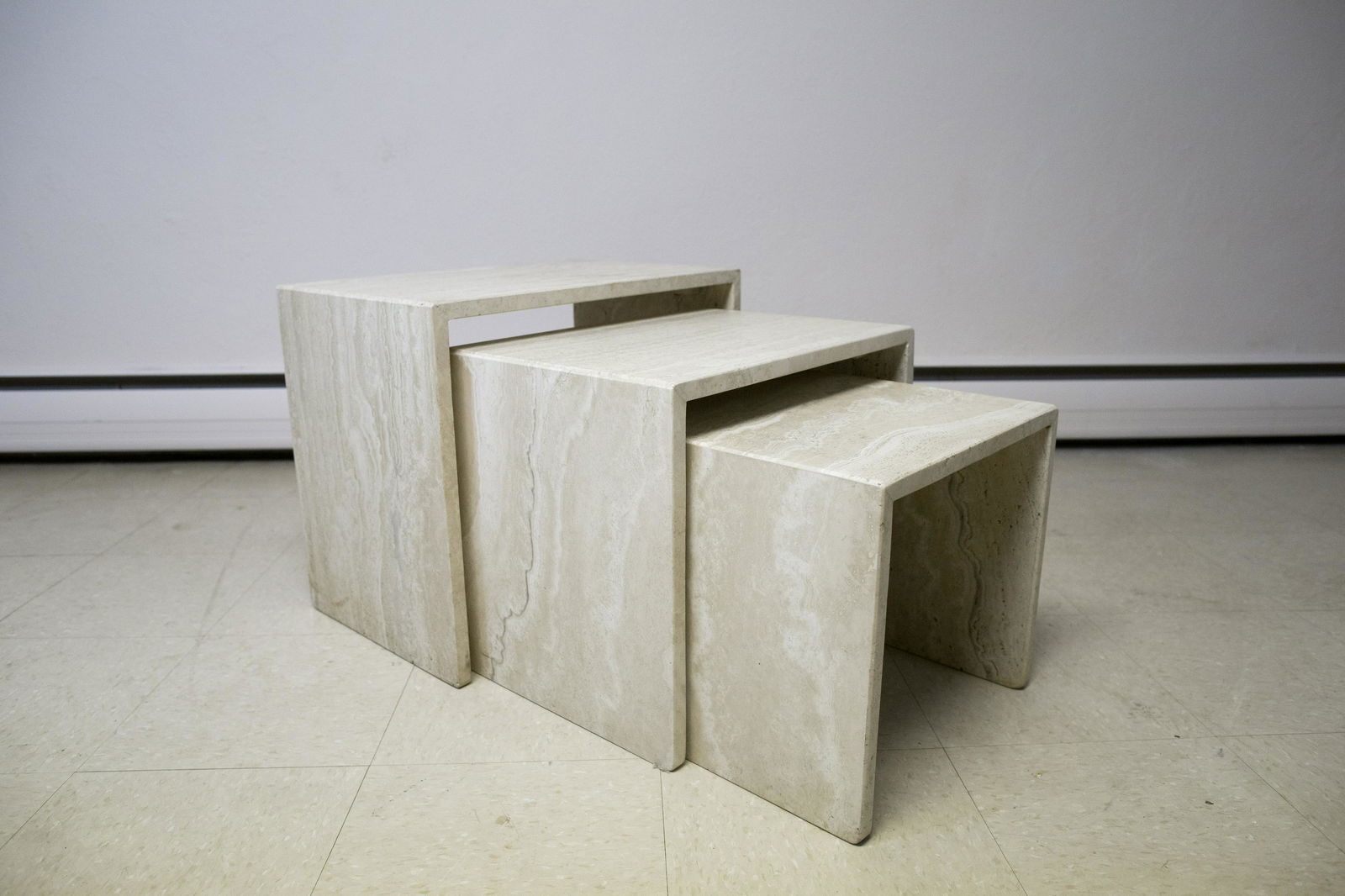 Set of 3 Polished Travertine Nesting Tables: DESCRIPTION: Set of three polished travertine nesting tables. MEASUREMENTS: Largest 21-3/4" wide x 13-3/4" deep x 18-1/4" high. CONDITION: Very good. Smallest with hairline to top.