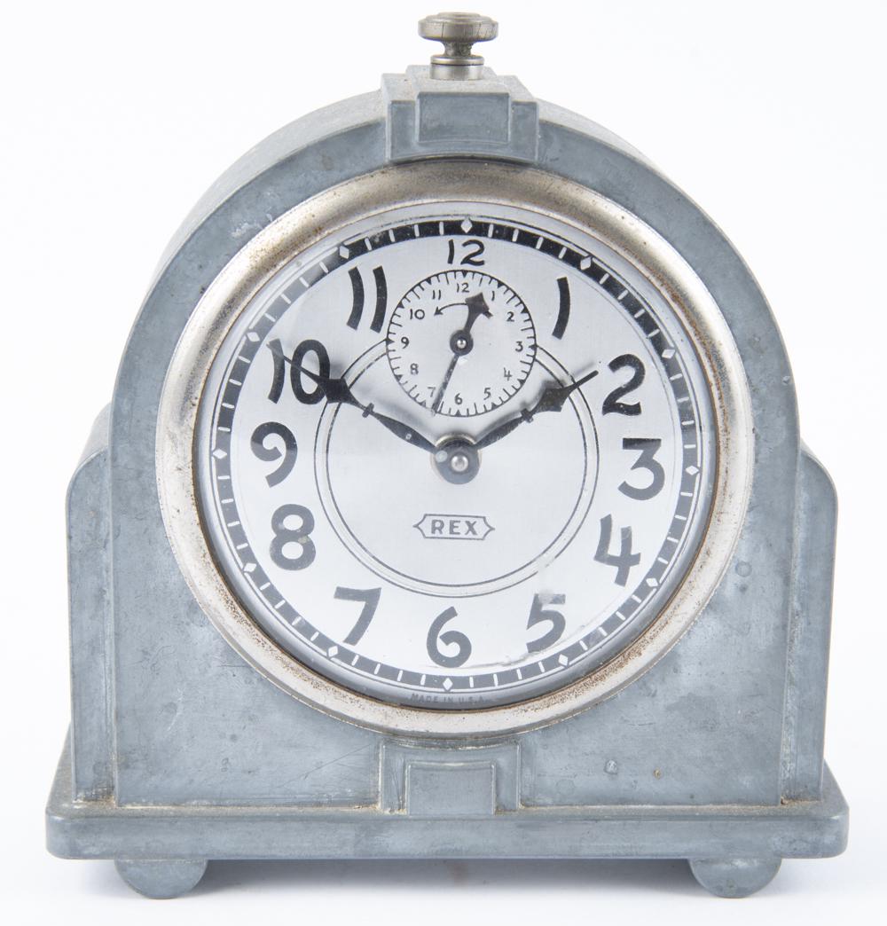 Rex Art Deco Alarm Clock: DESCRIPTION: Rex Art Deco alarm clock. Brushed aluminum case with aluminum dial. MEASURMENTS: 5-3/4" wide x 6-1/2" high. CONDITION: Running. Light corrosion to rear.
