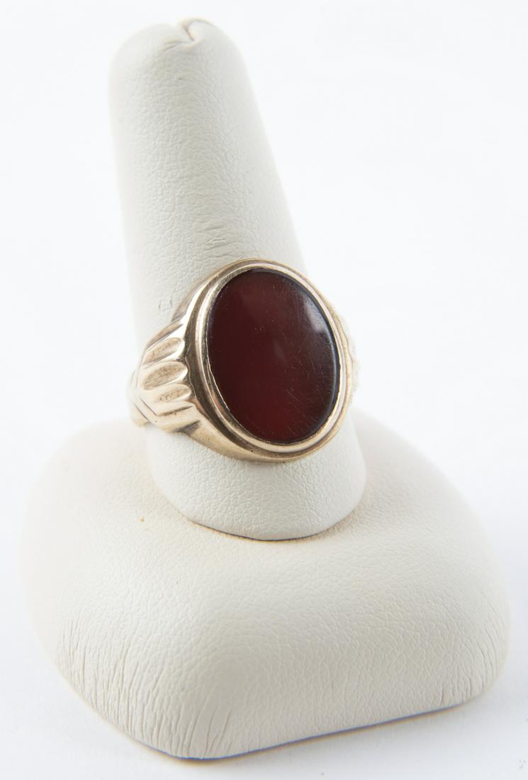 10k and Carnelian Stone Ring: DESCRIPTION: 10 stamped ring with oval carnelian stone. MEASUREMENTS: 2.8 dwt (4.3 gr). Size 8.75. CONDITION: Light wear including scratches and bends to shank.