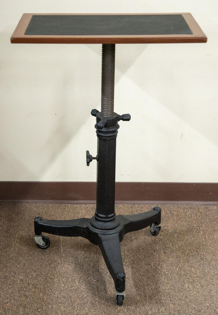 Vintage Adjustable Table with Iron Base: DESCRIPTION: Vintage adjustable height table with leather and wood top and iron base. MEASUREMENTS: 23" wide x 15" deep x 35" high.