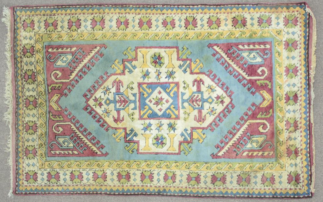 Turkish Kars Area Rug: DESCRIPTION: Turkish Kars area rug with diamond shaped center with floral pattern in cream, blue, pink green, and yellow on blue ground with border. Includes faded tag. Turkey, circa 1980s. MEASUREMEN