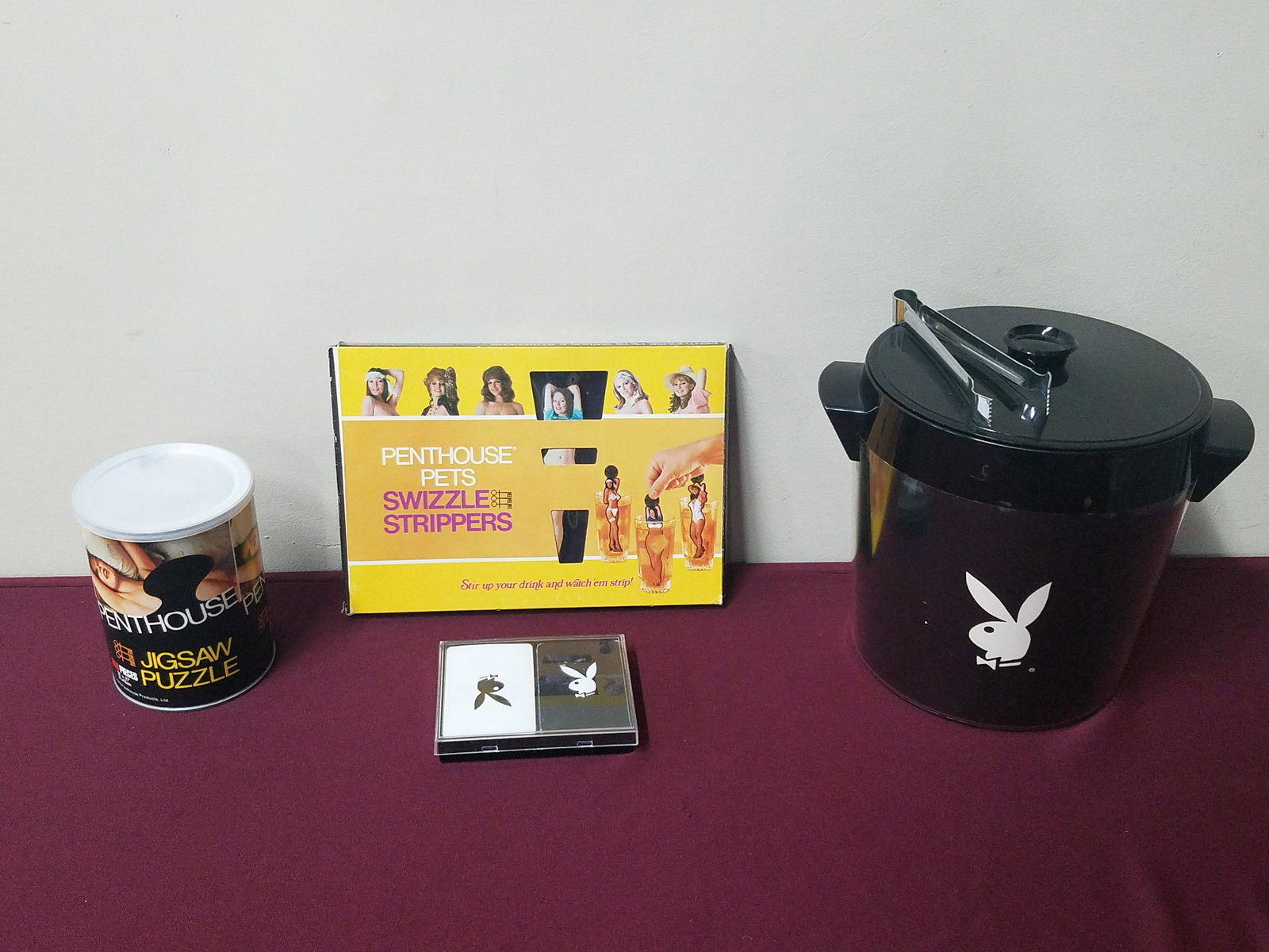 4 Pcs Playboy and Penthouse Collectibles: Includes Penthouse swizzle strippers and jigsaw puzzle. Also includes Playboy ice bucket and deck of cards. Jigsaw puzzle is factory sealed.