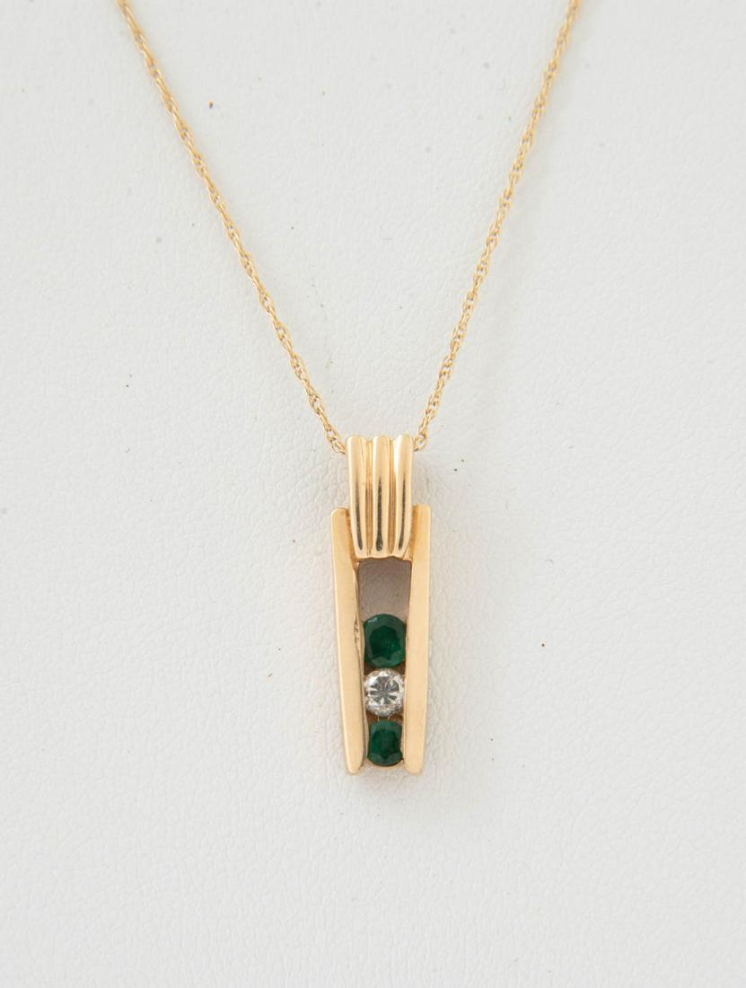 14k Diamond and Emerald Pendant on 14k Chain: DESCRIPTION: 14k stamped pendant channel set with two emeralds and one 6 point diamond, on 14k chain. MEASUREMENTS: 1.8 dwt ( 2.9 gr). Chain 18" long, pendant 7/8" long. CONDITION: Light wear.