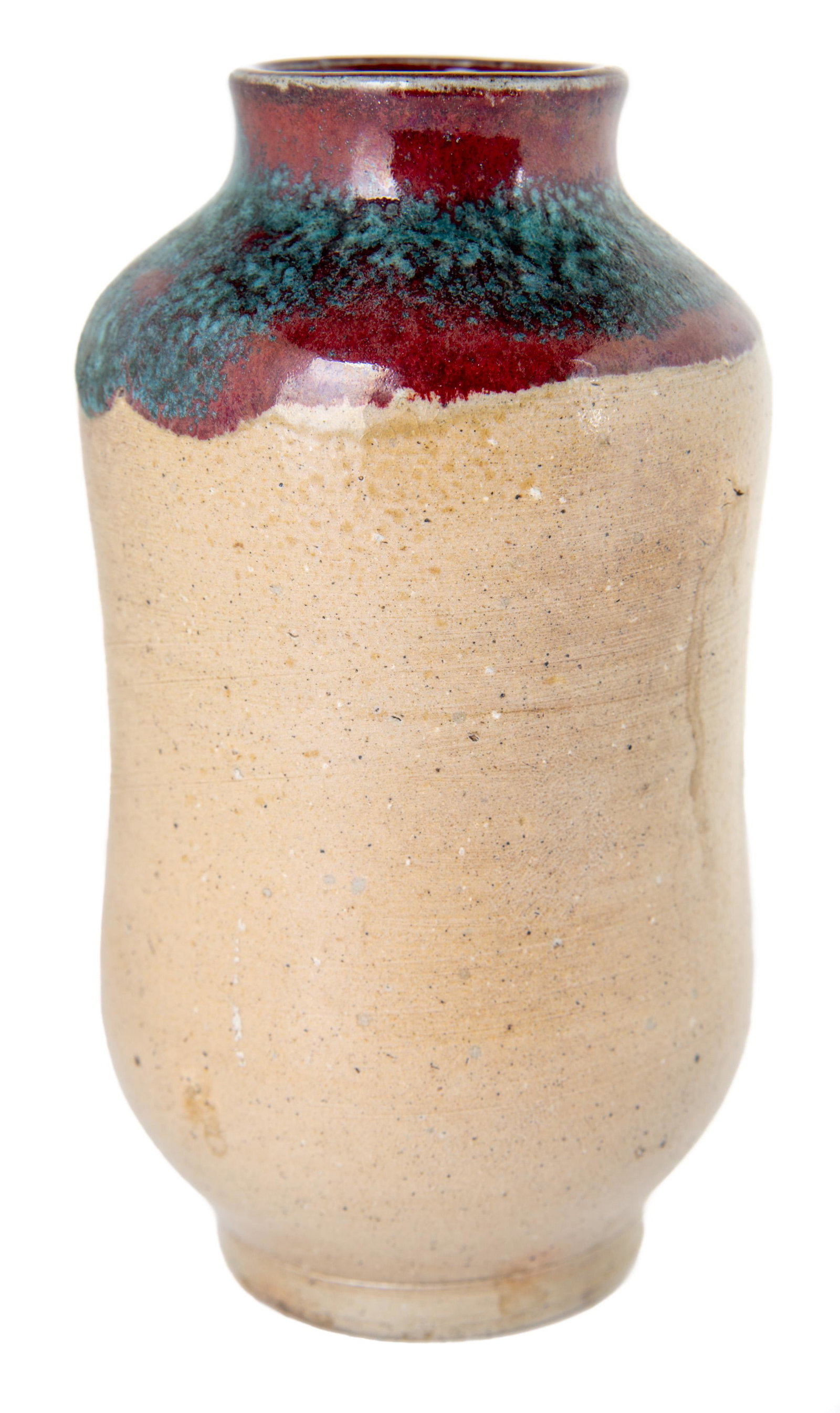 Jugtown Art Pottery Chinese Blue Vase: DESCRIPTION: Jugtown Ware art pottery vase. Salt glaze ground with Chinese red and blue glaze to upper quarter. Jugtown stamp to base. MEASUREMENTS: 4" x 7". CONDITION: No defects noted.