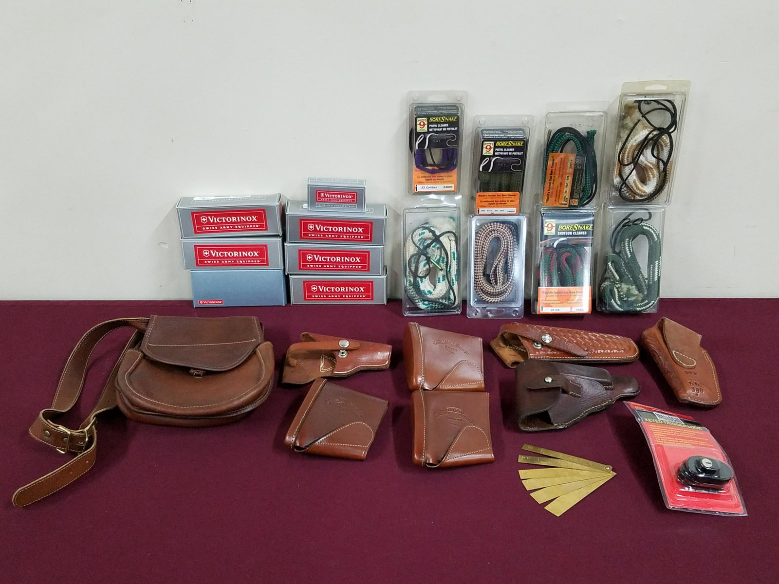 25 Pcs Leather Cases and Hoppe's Bore Snakes: Includes 8 Bore Snake Pistol Cleaners, 7 Victorinox swiss army cases, Orvis double leather porch, ETC.