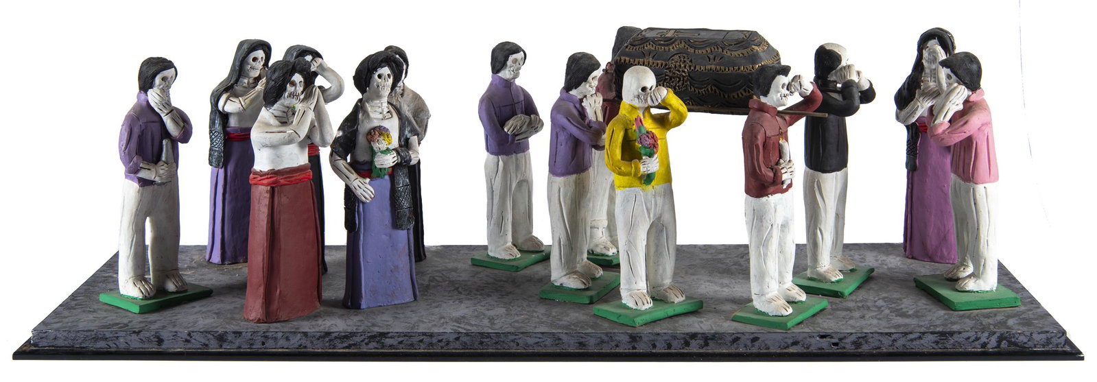 Dia De Los Muertos / Day of the Dead Diorama: Fourteen figurines in processional with casket. Each figure marked on back "L.V.M", probably for Latino Virtual Museum, Smithsonian Latino Center. In plexiglass case. Sculpted by Jeffrey Abraham (Cali