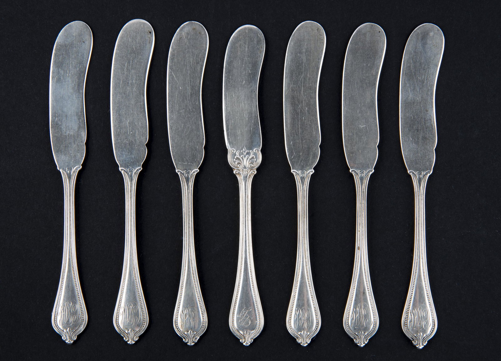 7 Towle Old Newbury Sterling Butter Spreaders: DESCRIPTION: Seven Towle Silversmiths sterling flat handled butter spreaders in the Old Newbury-Newbury pattern. With hallmark, "Sterling", and "928/1000". Monogrammed. MEASUREMENTS: 5-3/4". 4.9 ozt. 
