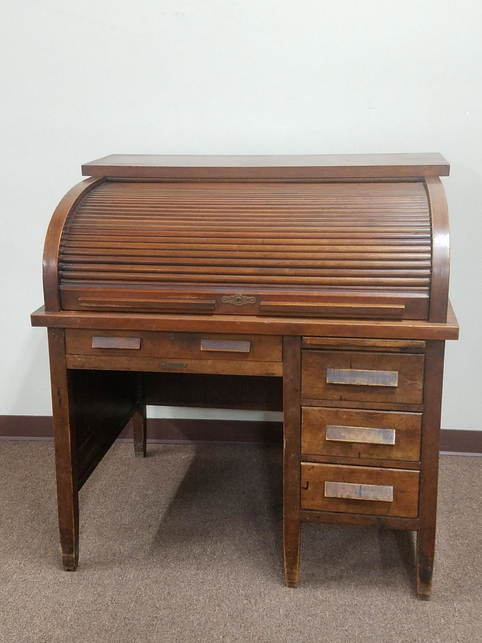 Royal Heckert Roll Top Desk: 42-1/4" wide x 32-1/4" deep x 43-1/2" high. Scratches and losses to wood finish. Key included.