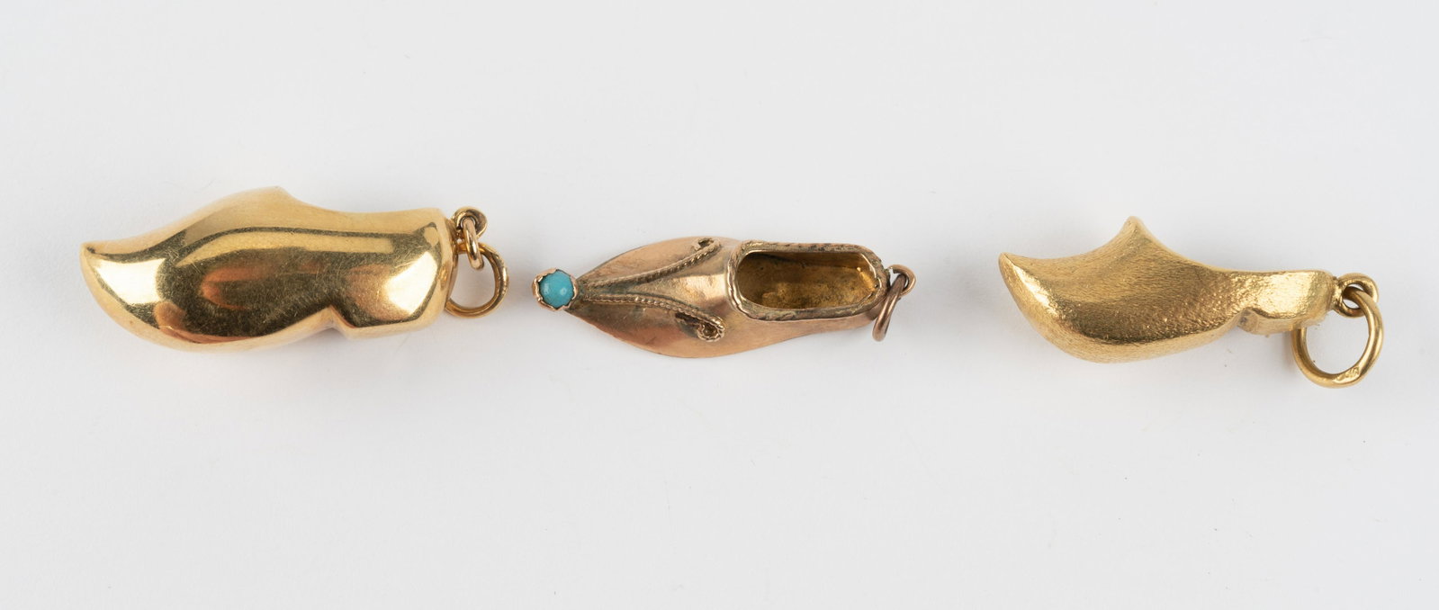 3 Gold Shoe Charms in 10K, 14K, and 18K: One marked 10K. One marked 14K. One marked 18K. Indian shoe marked with five pointed star. 6.1 dwt total. Largest 1-1/4". IMPORTANT: Before bidding, please read the terms and conditions below. When yo