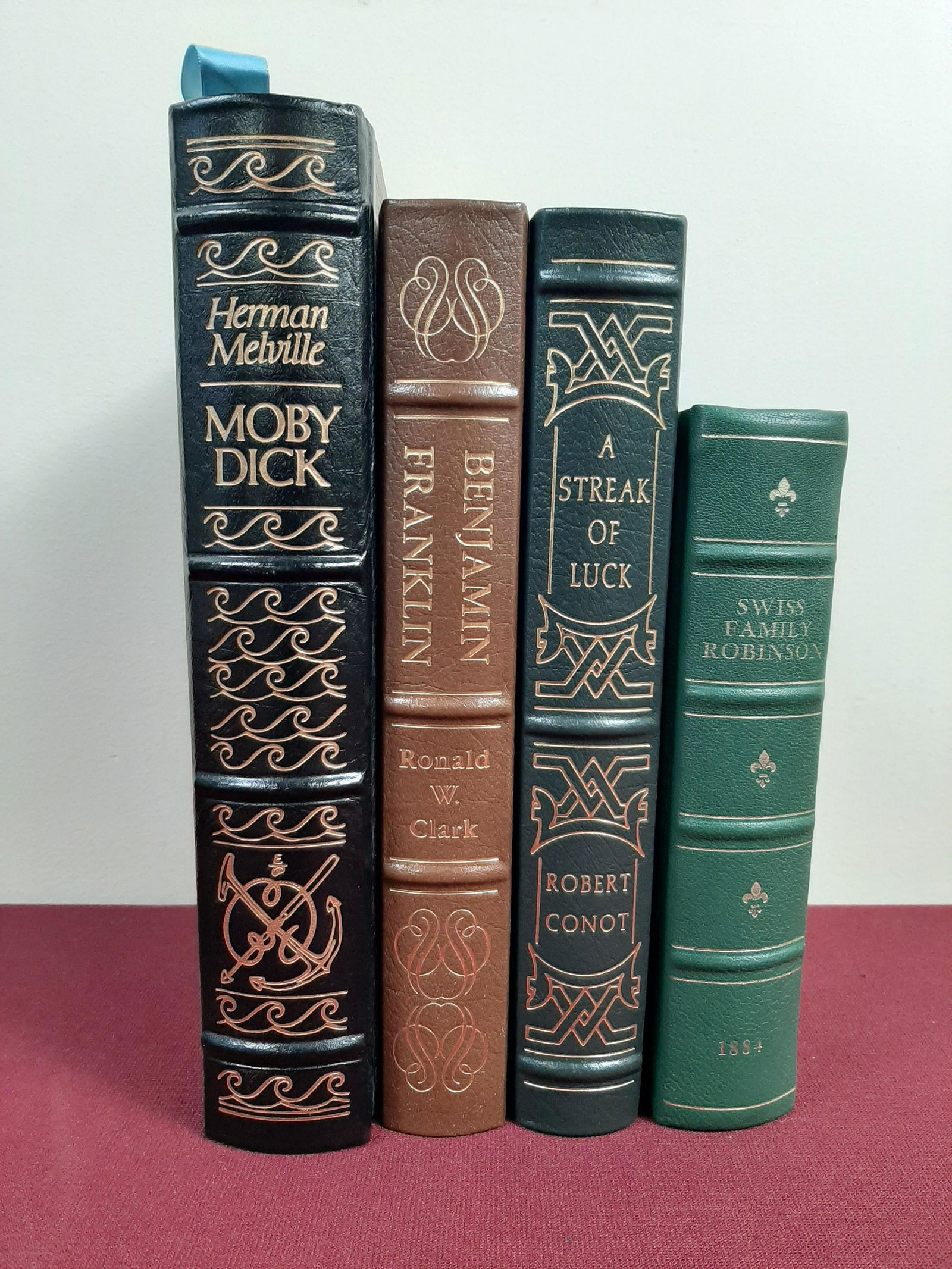 4 Leather Bound Books: Includes 1884 printing of The Swiss Family Robinson. Also includes Easton Press collector's edition of Moby Dick and biographies of Benjamin Franklin and Thomas Edison. IMPORTANT: Before bidding, plea