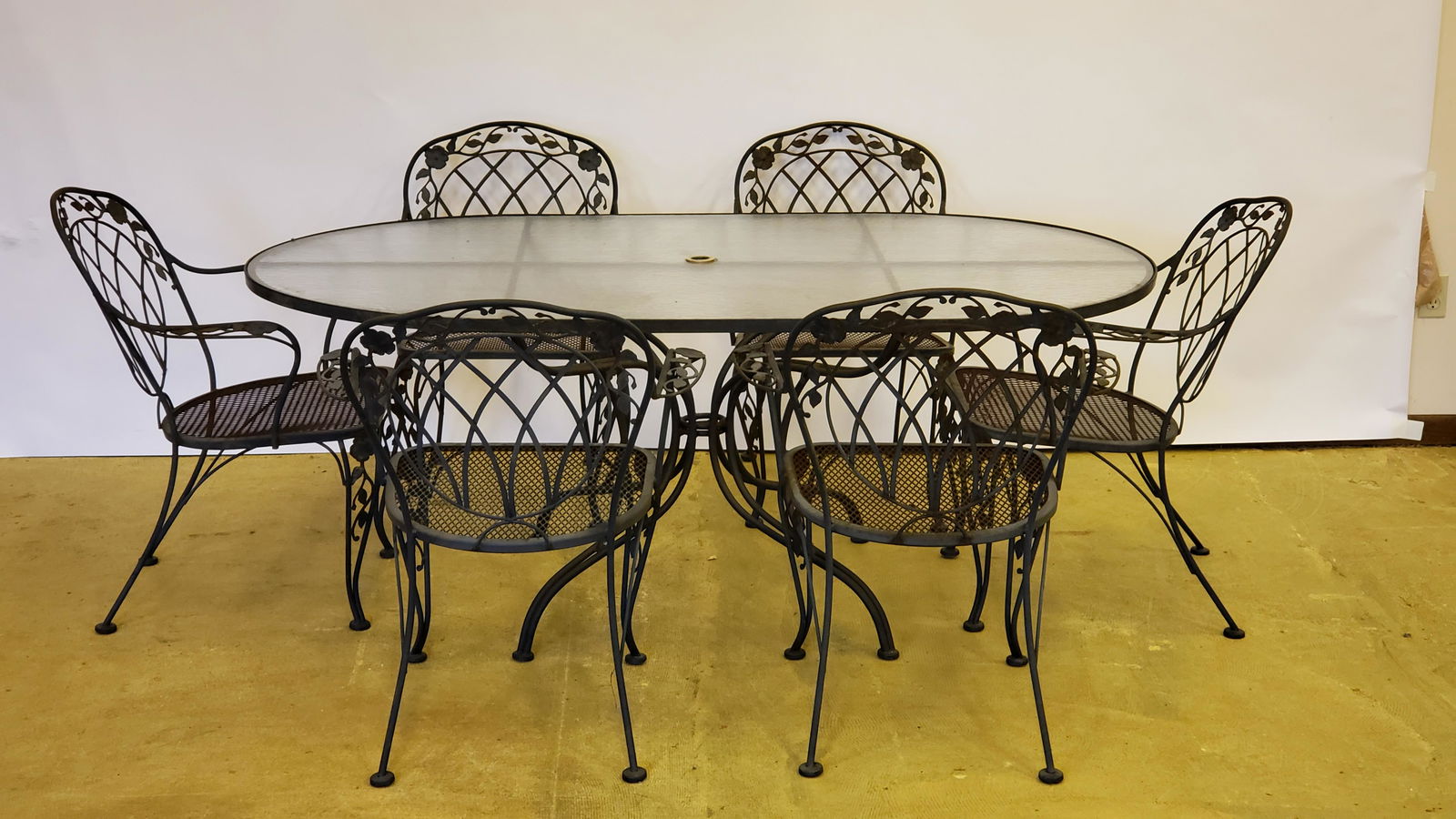 Outdoor Metal and Glass Table with 6 Chairs: Chairs with floral decoration. Includes umbrella. Table: 72-3/4" long x 42-1/2"wide x 29" high. Chairs: 27-1/4" wide x 26" deep x 33-1/2" high. Umbrella: 102" high. IMPORTANT: Before bidding, please r