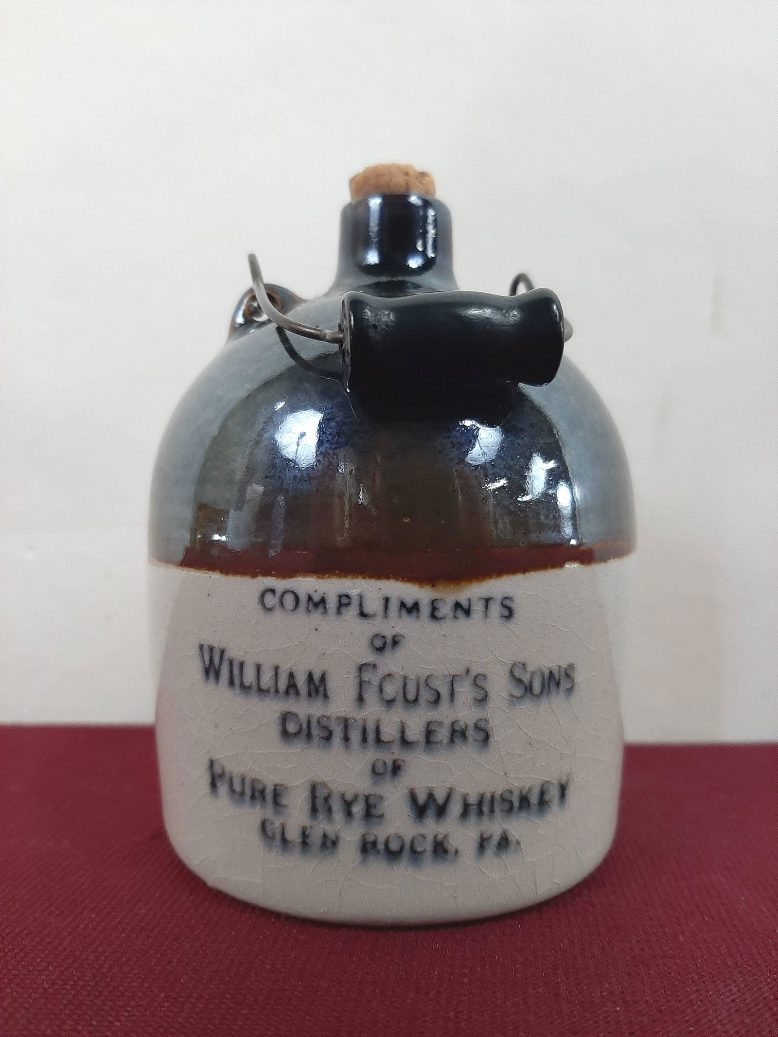 4" William Foust Distillers Advertising Bottle: 2 3/4" diameter X 4" high. IMPORTANT: Before bidding, please read the terms and conditions below. When you registered for the auction you agreed to these terms and will be required to comply with them