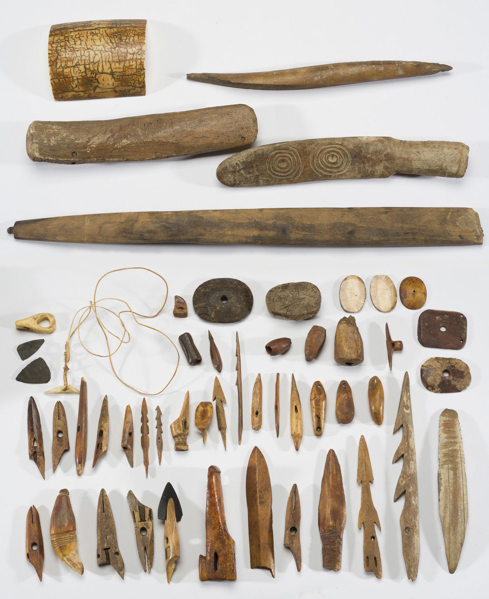 Assemblage of Native American Bone Tools: DESCRIPTION: Assemblage of Native American bone and antler tools, primarily from Alaska. Includes net weights, harpoon tips and toggles, awls, gorgets, beedles, and a small duck effigy. MEASUREMENTS: