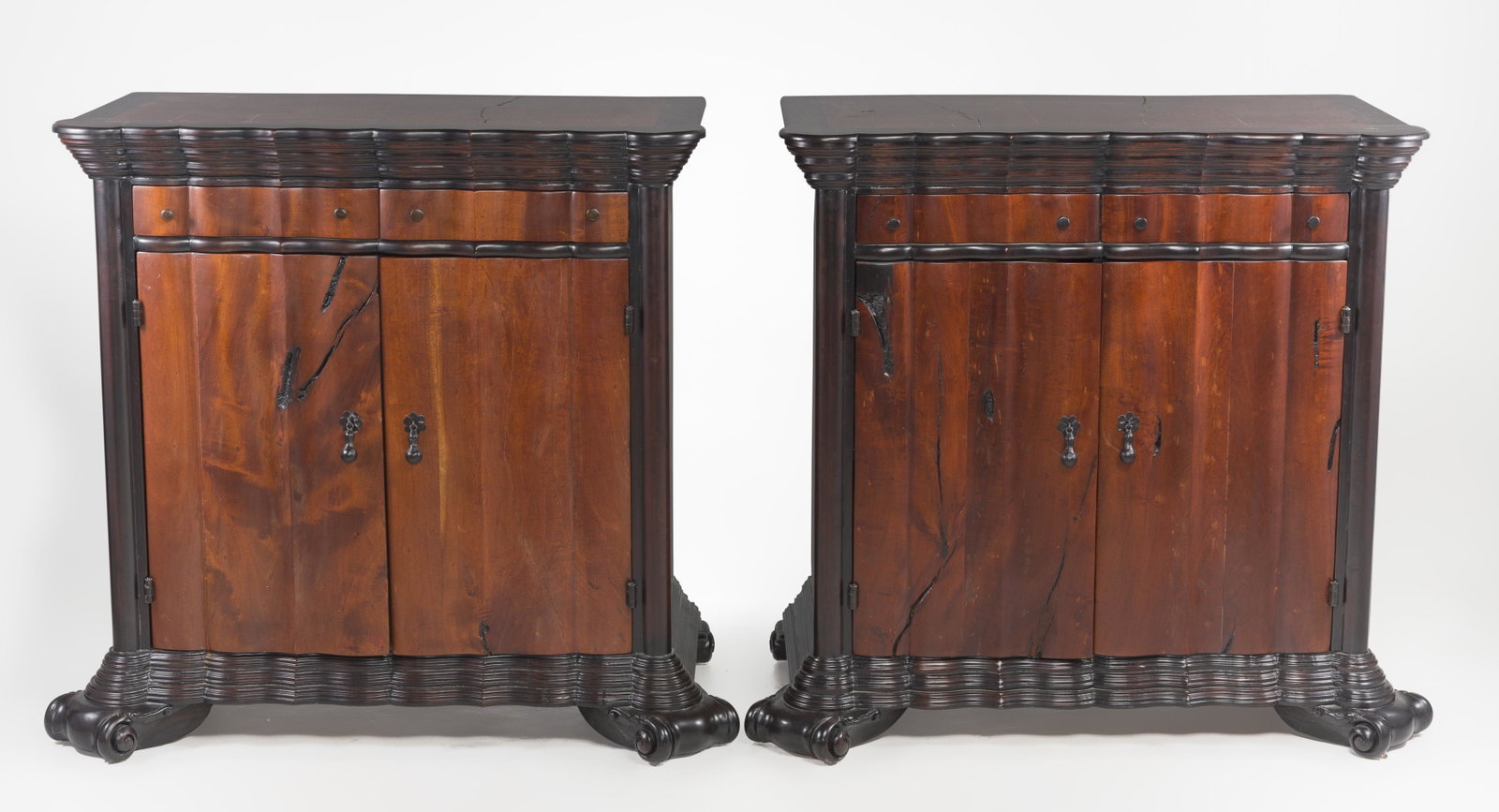 Pair of Hand Carved Mesquite and Cabino Cabinets: DESCRIPTION: Pair of hand carved mesquite and sabino wood cabinets. Scalloped top and base on carved scroll feet. Two drawers over two doors. Purchased from Casa del Encanto Interiors of Scottsdale, A