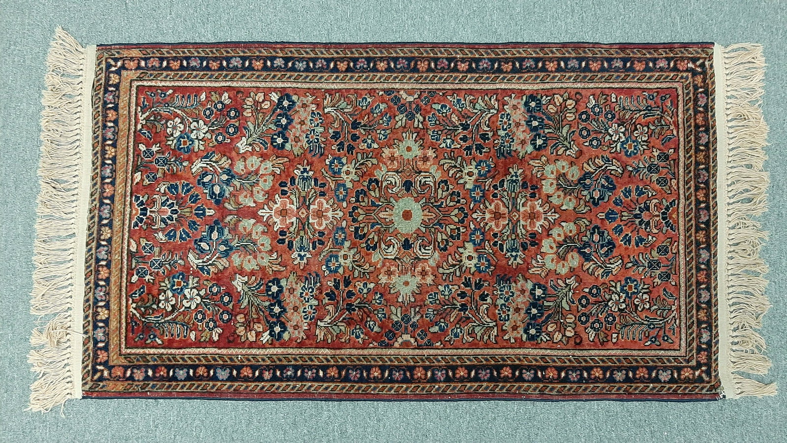 Persian Sarouk Area Rug: Red field with blue and cream highlights on floral pattern. Made in Iran in the first half of the 20th century. 4' 5" long x 2' 2 1/2" wide. IMPORTANT: Before bidding, please read the terms and condit