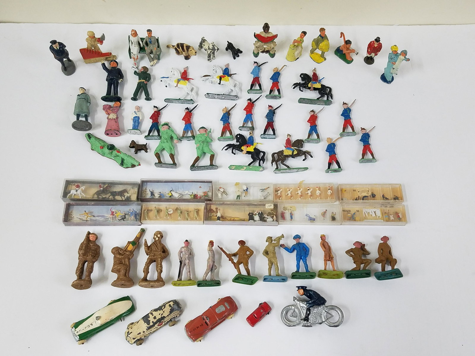 63 Miniature Figures, Dogs and Soldiers: 3/4" to 4" high. The lot contained metal, plastic and paper mache figures. IMPORTANT: Before bidding, please read the terms and conditions below. When you registered for the auction you agreed to thes