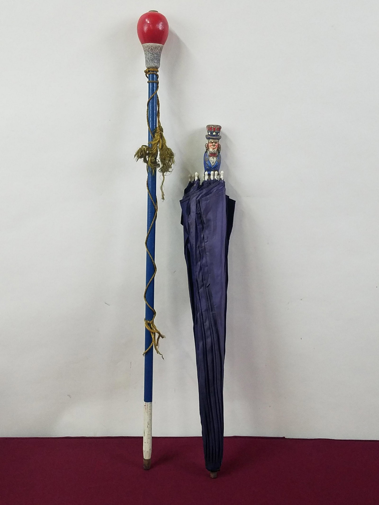 Uncle Sam Parasol and Majorette Baton: 22-1/2" to 29" long. Some paint losses. IMPORTANT: Before bidding, please read the terms and conditions below. When you registered for the auction you agreed to these terms and will be required to com