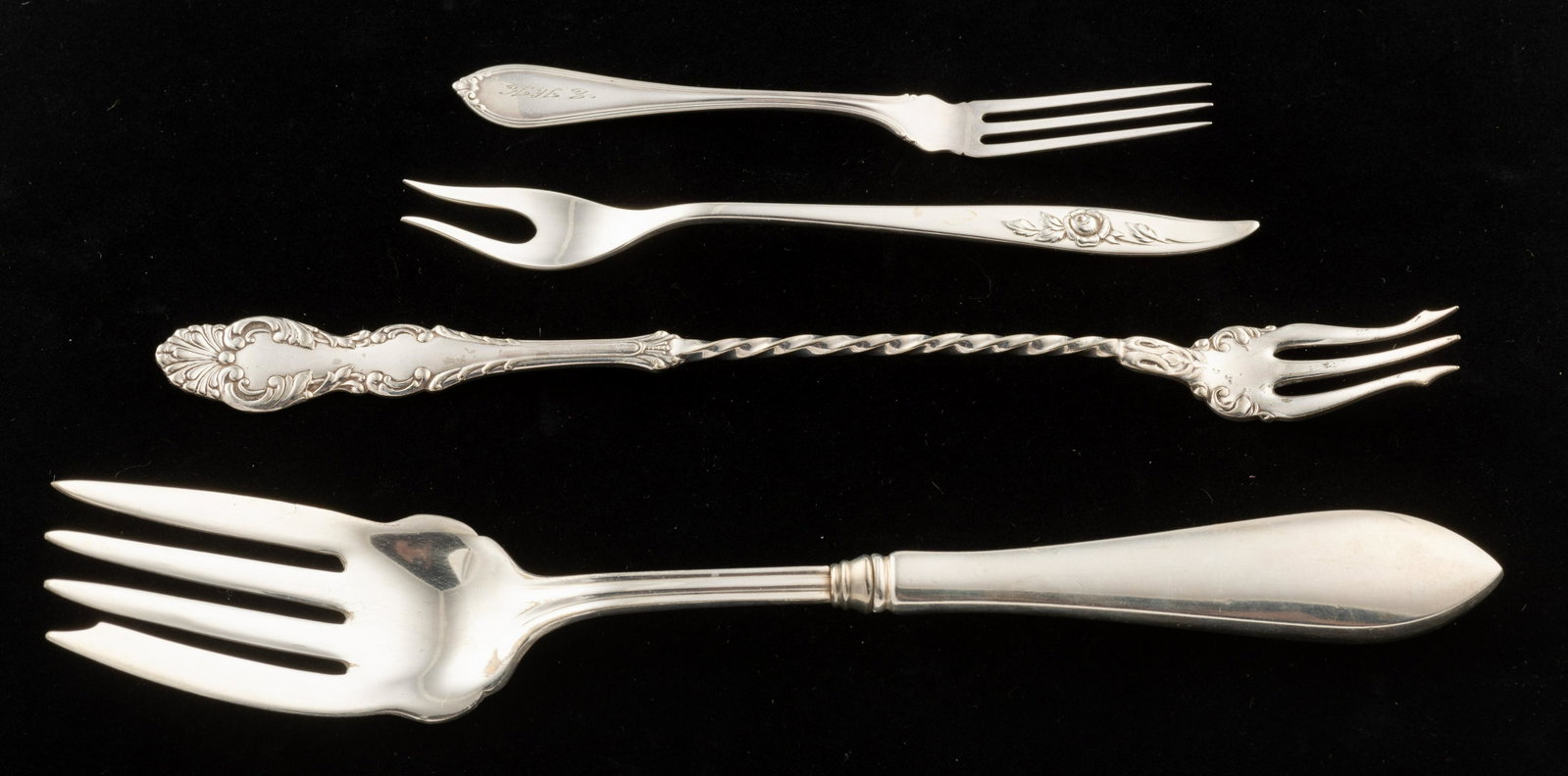 4 Sterling Forks: Niagara Falls long-handled pickle fork, GHF salad fork (hollow handled), Heirloom short-handled pickle fork in Belle Rose pattern, and Alvin strawberry fork. 5" to 8 1/2" long. 2.19 ozt total (hollow 