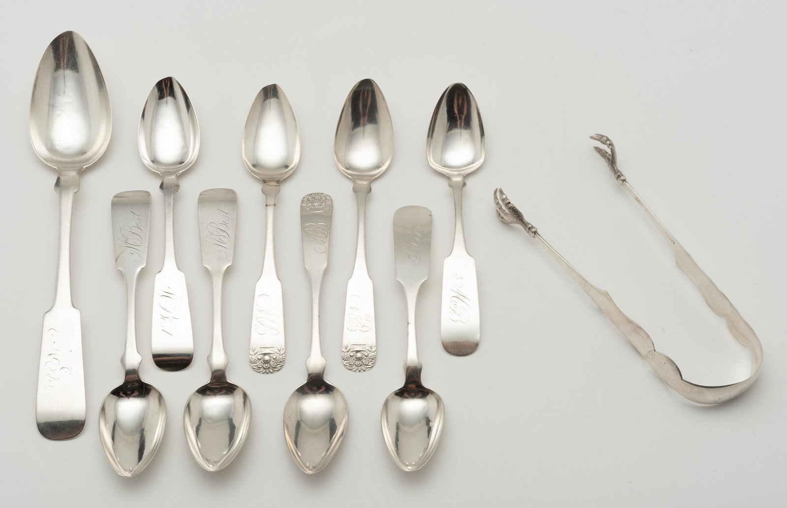 9 Coin Spoons & Tongs: W. Griswold serving spoon, 3 A.G. Storm fruit spoons, tongs with anchor, bust, and star pseudo mark, 3 teaspoons with eagle, D, and star pseudo mark & 2 C. Yates tablespoons. 6" x 8 1/4" long. 6.5 ozt