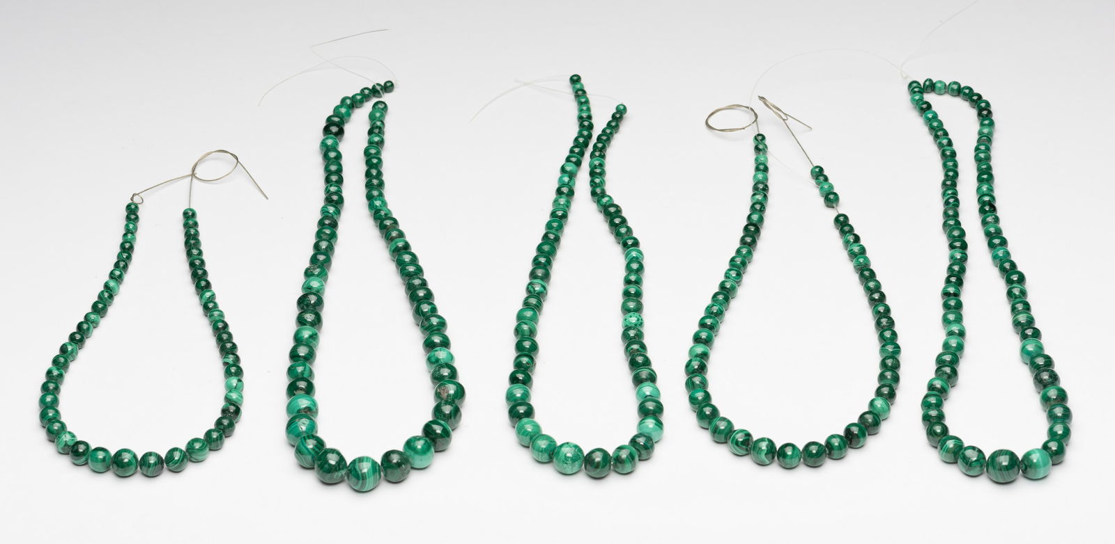 105" Strung Malachite Beads: 5 strings. Bead sizes range from 5.7mm to 15.4mm. 2,522 carats/16.22 ozt. IMPORTANT: Before bidding, please read the terms and conditions below. When you registered for the auction you agreed to these