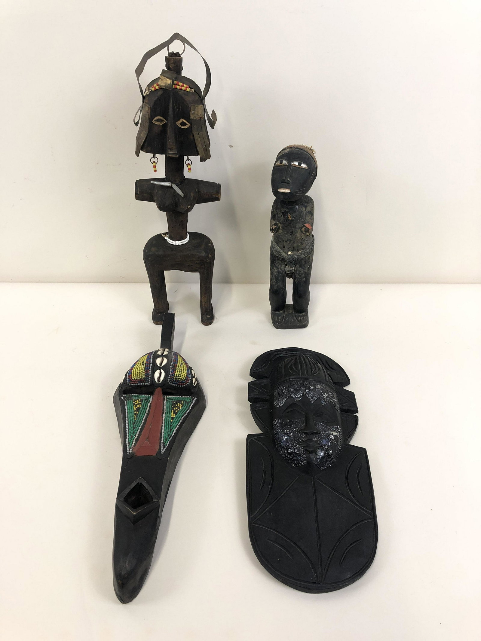 4 Pcs African Art: Statues and masks include beaded. 11 1/2" to 19 3/4" high x 3" to 7" wide.
