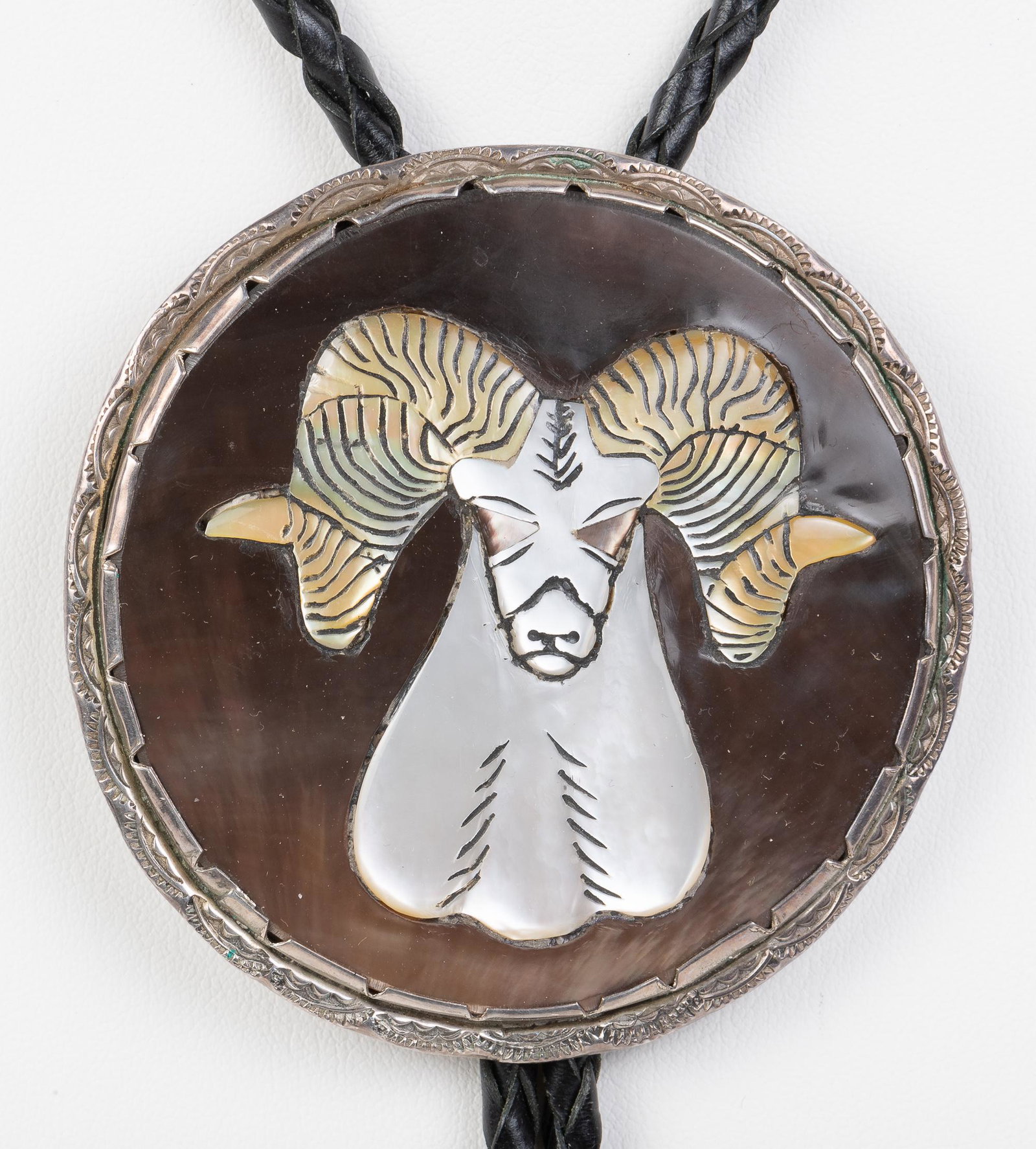 Vintage Effie Qualo Zuni Dall Sheep Bolo: Handmade, sterling silver slide with mother-of-pearl inlay. Signed. Slide 2-3/4". Black braided cord 35" long. Silver tips 2" long. IMPORTANT: Before bidding, please read the terms and conditions belo