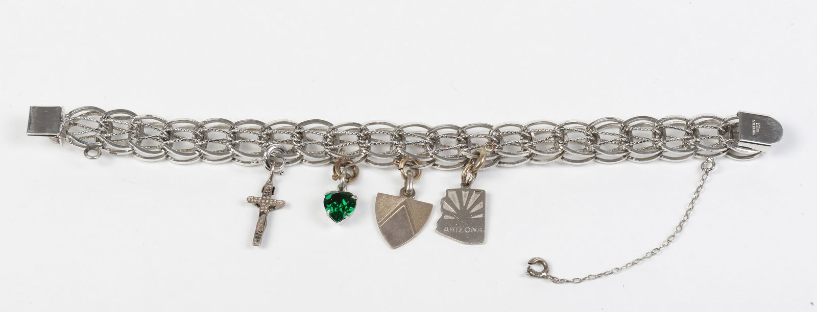 Sterling Charm Bracelet: With four charms. 0.76 dwt. 7-1/4" long. IMPORTANT: Before bidding, please read the terms and conditions below. When you registered for the auction you agreed to these terms and will be required to co